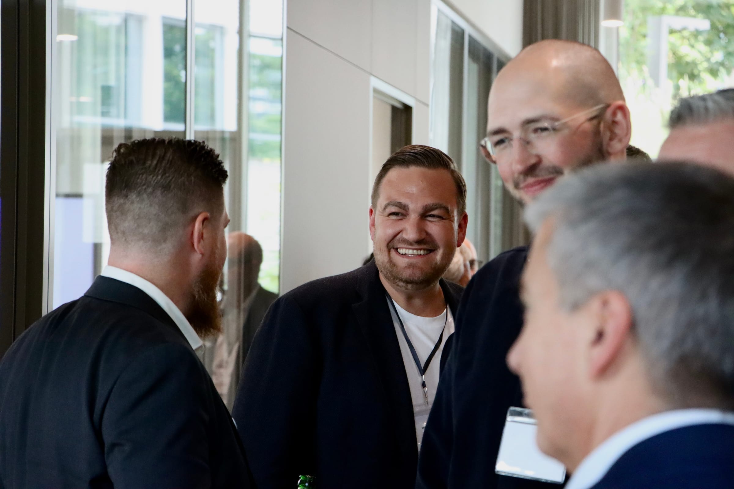 Attendees networking and sharing a laugh at the forum